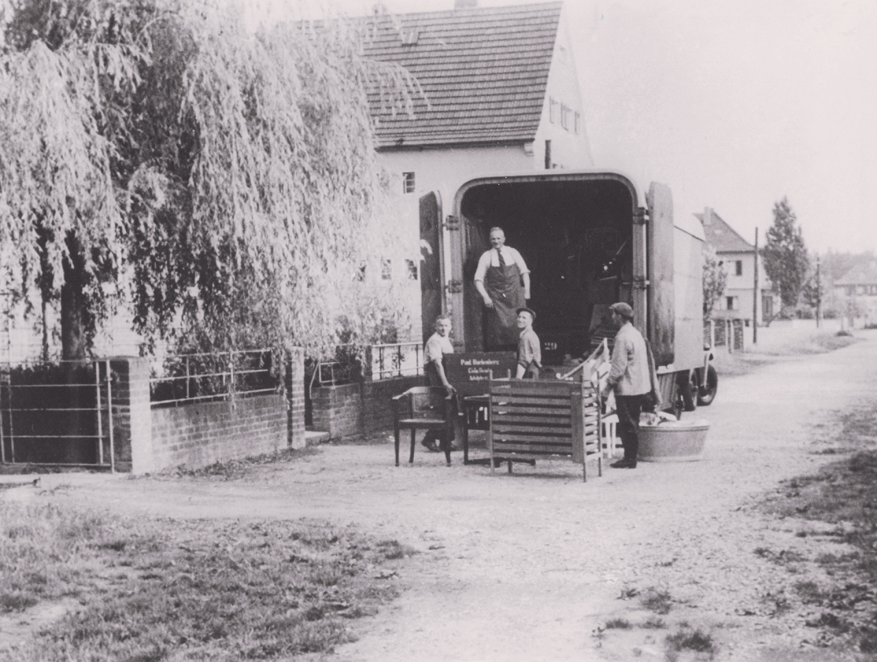 Ein altes Foto, das Roggendorf-Mitarbeiter beim Beladen eines Transporters zeigt